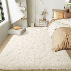 a bedroom with a large white rug on the floor next to a bed and window