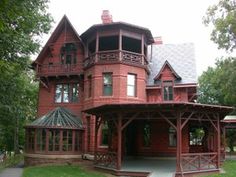 a large red house sitting on top of a lush green field