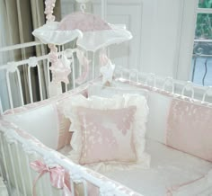 a baby crib with pink and white decor