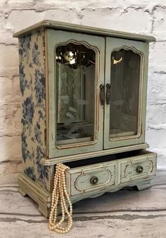 an old china cabinet with pearls on the bottom