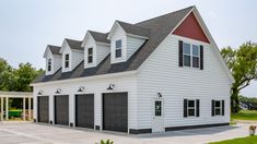 a white house with black garage doors and windows