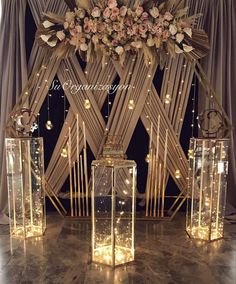 an arrangement of vases with flowers and lights