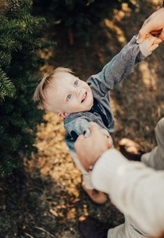 a man holding the hand of a small child who is reaching out to touch him