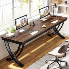 a computer desk with two monitors on it and a chair in front of the window