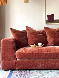 a red couch sitting on top of a blue rug