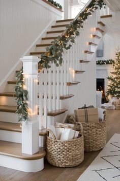 the stairs are decorated with garland and christmas lights, along with baskets filled with presents