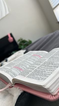 an open book sitting on top of a bed