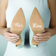 a woman holding two pairs of shoes that say it's mine