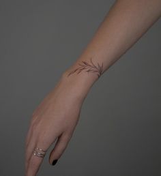 a woman's hand with a small tattoo on the left side of her wrist