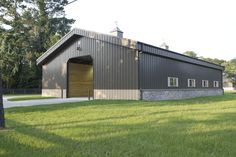 a large metal building sitting on top of a lush green field