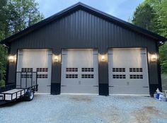 two garages are shown with lights on the side and one has a trailer attached to it