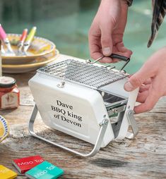 a person using a grater to grate cheese on a table with beer bottles and plates