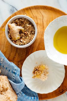 a bowl of oatmeal next to a plate with bread and olive oil