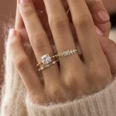 a woman's hand with two rings on it and one ring in the middle