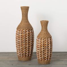 two vases made out of wicker sitting on a wooden table next to each other