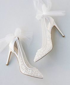 the bride's wedding shoes are adorned with white lace and bowknots