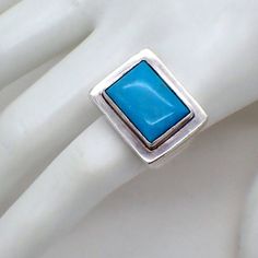 "EXEX Claudia Agudelo sterling silver ring with rectangular front, decorated with Turquoise stone. This catchy ring is a size 9 and weighs 19.9 grams. The front part measures 15/16\" x 3/4\". EA2572" Rectangular Turquoise Gemstone Ring, Rectangular Turquoise Ring Gift, Rectangular Blue Turquoise Sterling Silver Ring, Rectangular Turquoise Ring For Anniversary, Rectangular Turquoise Rings For Anniversary, Rectangular Blue Turquoise Gemstone Ring, Anniversary Turquoise Rectangular Ring, Anniversary Rectangular Turquoise Ring, Silver Rectangular Turquoise Gemstone Ring