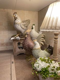 three chickens sitting on top of a table next to a lamp