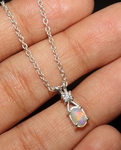 Opal Birthstone Necklace With Oval Pendant, White Gold Opal Oval Necklace, White Gold Opal Necklace With Oval Shape, Oval Opal Necklace In White Gold, Silver Opal Dainty Necklace, Silver Opal Jewelry In Oval Cabochon Shape, Silver Opal Necklace In Dainty Style, Silver Opal Oval Pendant Jewelry, Ethiopian Opal Oval Pendant