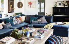 a living room filled with lots of blue couches and pillows on top of a wooden table