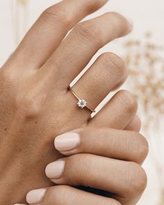 a woman's hand with a ring on it and a diamond in the middle