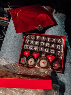 a red box filled with chocolates sitting on top of a table