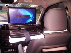 a laptop computer sitting on top of a car seat in the passenger's side