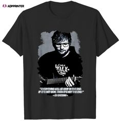 a black t - shirt with an image of a man holding a guitar in his hand