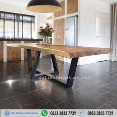 a large wooden table sitting in the middle of a room with black tile flooring