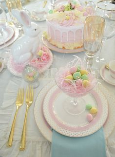 the table is set for easter dinner with pink and white decorations