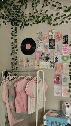 a room filled with lots of different items and plants on the wall above clothes racks