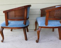 two chairs sitting next to each other in front of a white wall with a window