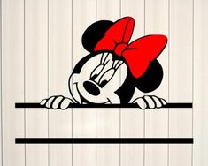 a mickey mouse with a red bow on it's head peeking over a fence