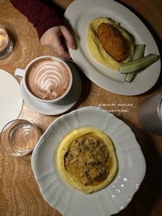 two white plates topped with food and drinks