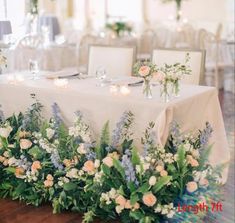 the table is set with flowers and candles for an elegant wedding reception or special event