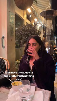 a woman sitting at a table with a wine glass in front of her and the caption reads men have the auductity and pretty much nothing else