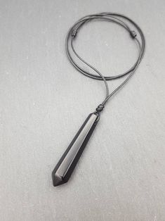 This listing is for 1 (one) necklace.  Materials: - natural Black Obsidian pendant approx. 50mm x 10mm - waxed braided polyester cord Please 💗 my shop to be updated on new creations : AnaDream - https://www.etsy.com/ca/shop/AnaDream IMPORTANT - PLEASE READ ✤ Necklace sizing (Exception: adjustable cord necklaces) ✤ It is very important to select the correct length when you place the order. Please make sure to measure your neck (or an older necklace you own) before purchasing and select the prope Black Pendant Crystal Necklaces For Meditation, Black Crystal Pendant Necklaces For Meditation, Black Pendant Crystal Necklace For Meditation, Minimalist Black Pendant Crystal Necklace, Pendulum Necklace, Cord Necklaces, Crystal Pendulum, Black Obsidian, Men Jewelry