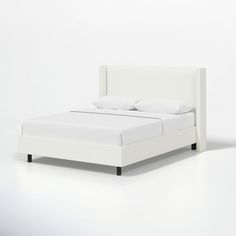 a bed with white sheets and pillows on it's headboard, against a plain background