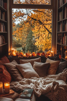 a cozy room with bookshelves and candles on the windowsill is filled with fall leaves