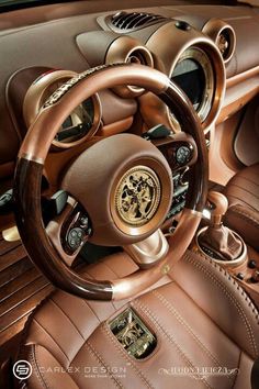 the interior of a car with brown leather seats and steering wheel covers, including an emblem on the center console