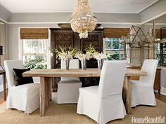 a dining room table with white chairs around it