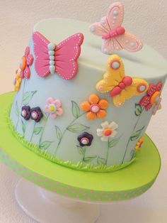 a colorful cake decorated with butterflies and flowers