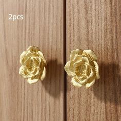 two gold flower knobs on wooden doors