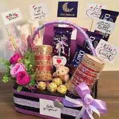 a gift basket filled with chocolates, candy and flowers on top of a table