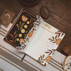 an open book sitting on top of a table next to some other items and papers