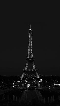 the eiffel tower lit up at night in black and white with text overlay