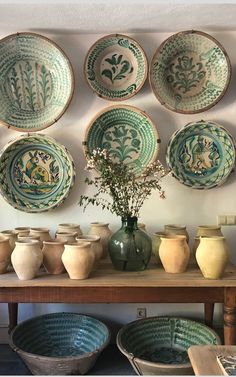 there are many vases and bowls on the table