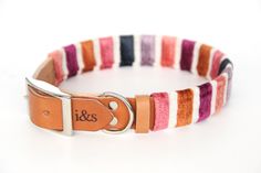 a dog collar with an orange, pink, and white stripe pattern on the front