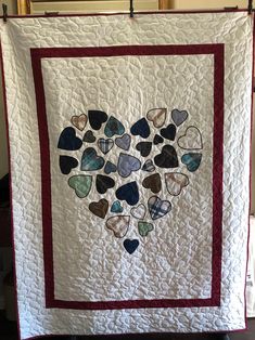 a quilted heart is hanging on the wall