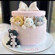 a pink cake decorated with cats and kittens